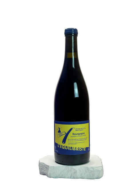 Wine bottle with a blue and yellow label on a white surface