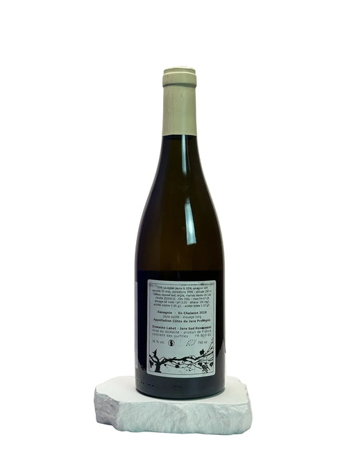 Wine bottle with label on a white surface against a light gray background