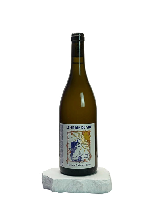 Wine bottle labeled 'Le Grain du Vin' on a white surface with a light gray background