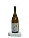 Wine bottle labeled 'Le Grain du Vin' on a white surface with a light gray background