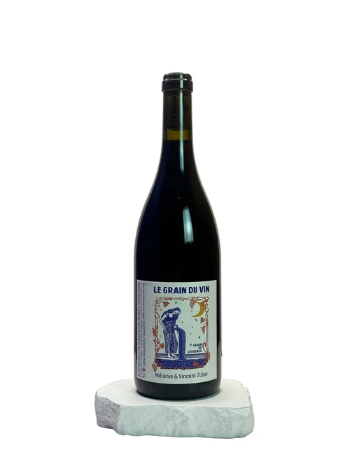 Wine bottle labeled 'Le Grain du Vin' on a white surface with a light gray background