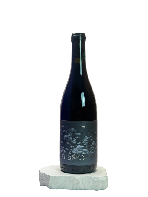 Wine bottle with a label on a white surface against a light gray background