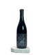 Wine bottle with a label on a white surface against a light gray background