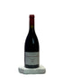 Red wine bottle on a white surface with a neutral background